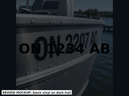 Black boat registration numbers applied on a charcoal hull, matched bow pair