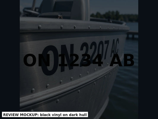 Black boat registration numbers applied on a charcoal hull, matched bow pair