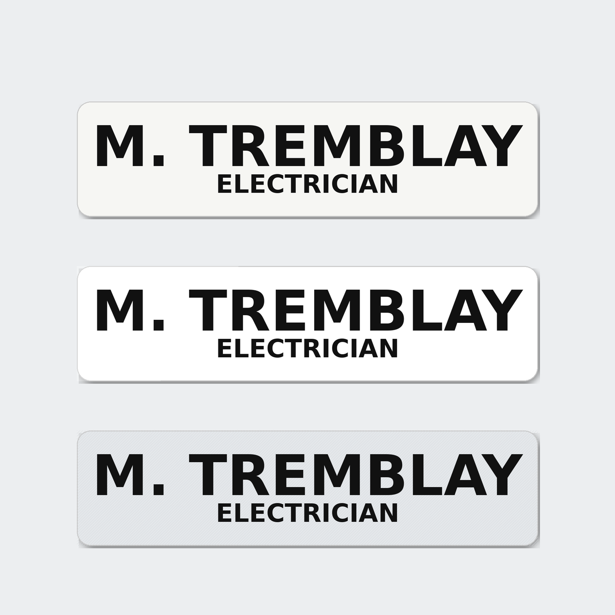 Three hard hat name stickers reading M. Tremblay, Electrician, in matte, gloss and reflective white.