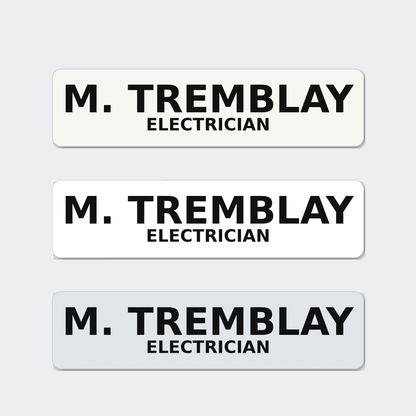 Three hard hat name stickers reading M. Tremblay, Electrician, in matte, gloss and reflective white.
