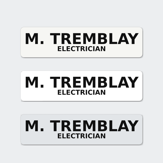 Three hard hat name stickers reading M. Tremblay, Electrician, in matte, gloss and reflective white.