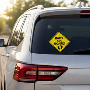Baby on Board vinyl decal installed on the rear window of a silver SUV in warm daylight.