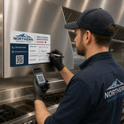 Close view of a hood cleaning service record sticker showing blank writable fields and QR code area