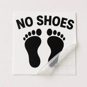 Black No Shoes footprint boat decal shown under clear transfer tape before installation