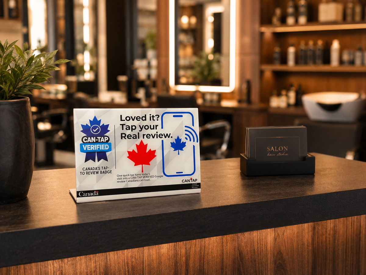 A NFC review card with the CAN-TAP Verified logo is displayed on a reception desk in a modern salon setting.