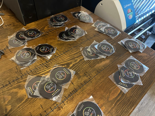 Stacks of NFC review cards with Google branding and five-star ratings are neatly arranged on a wooden table in an office setting.