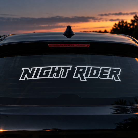 Outlined Night Rider lettering on a dark car's rear window at dusk.