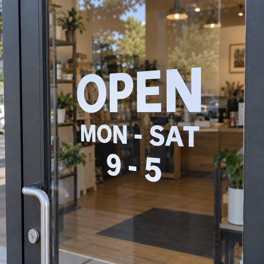 White cut vinyl lettering showing opening hours on a shop's glass door