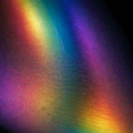 Macro view of iridescent holographic vinyl film showing the prismatic colour shift at an angle